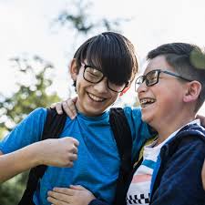 2 boys wearing glasses, hugging and laughing
