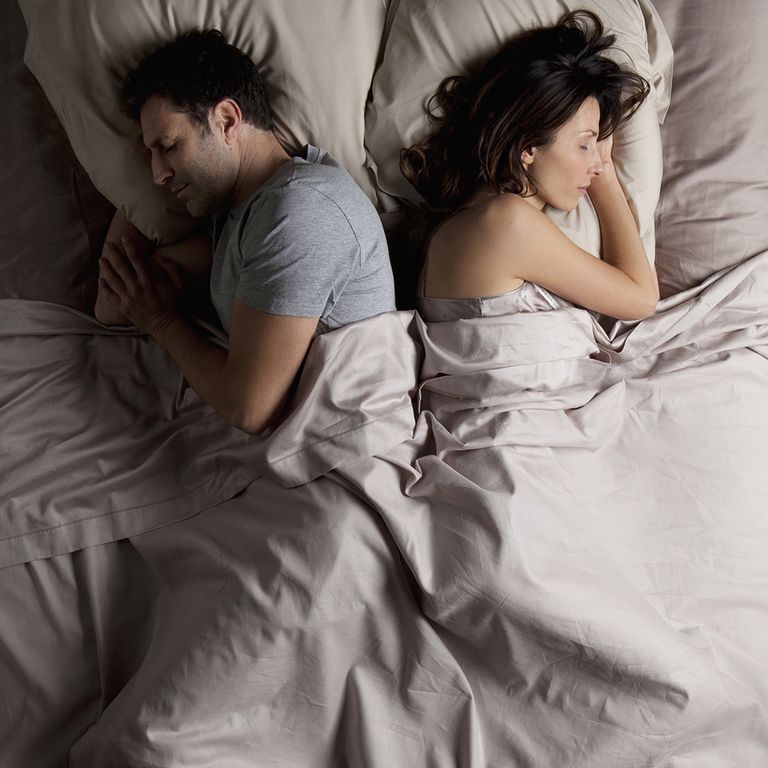 A couple facing away in bed after an argument