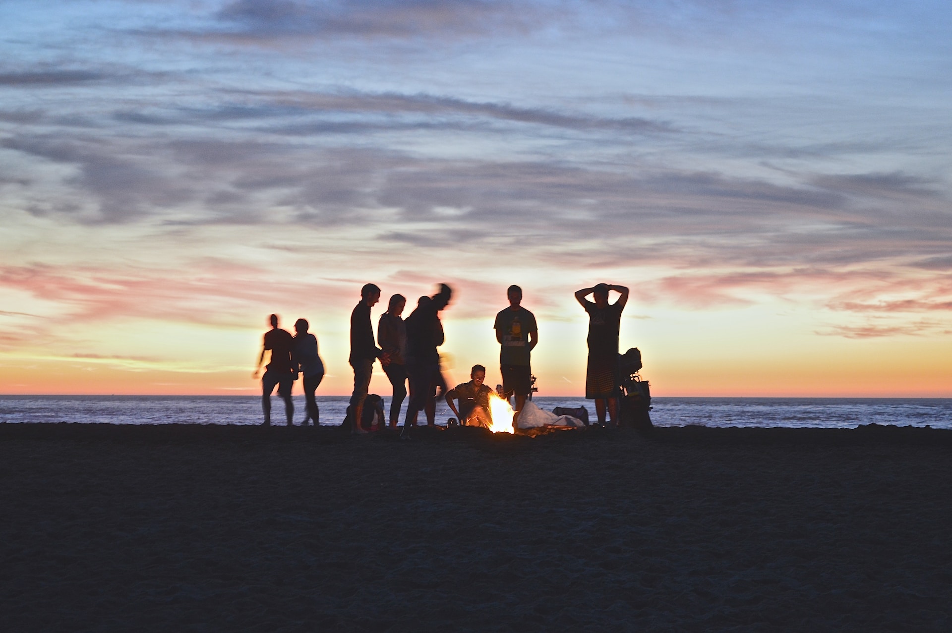 Group of people having a bonfire on the beach